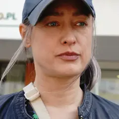 Matylda Damięcka w czapce i skórzanej kurtce, zamyślona. Może myśli o swoich dzieciach?