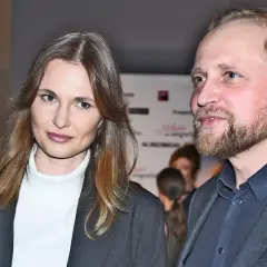Piotr Adamczyk z żoną, piękną kobietą o długich włosach, na wydarzeniu.