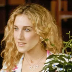Sarah Jessica Parker w jednym ze swoich filmów, z burzą blond loków i delikatnym uśmiechem.