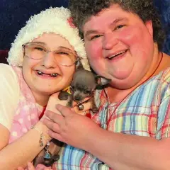 Gypsy Rose Blanchard i jej matka, Dee Dee, uśmiechają się do aparatu, trzymając małego psa.