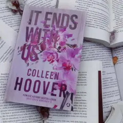 Książka "It Ends With Us" Colleen Hoover na tle innych otwartych książek.