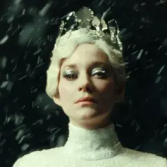Marion Cotillard w koronie i błyszczącej sukni, otoczona śniegiem, jak z jej filmów.