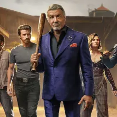 Sylvester Stallone jako Dwight Manfredi z kijem baseballowym, otoczony przez ekipę. Zapowiedź Tulsa King sezon 3.