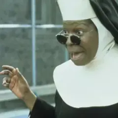 Whoopi Goldberg w roli siostry w filmie "Zakonnica w przebraniu 2: Powrót do habitu" z okularami i w rozbawionej pozie.