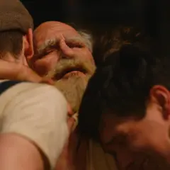 Trzech mężczyzn w uścisku. Starszy mężczyzna z brodą, bo się boi, przytulony przez dwóch młodszych.