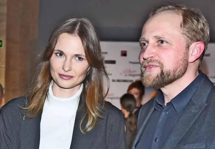 Piotr Adamczyk z żoną, piękną kobietą o długich włosach, na wydarzeniu.