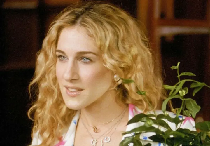 Sarah Jessica Parker w jednym ze swoich filmów, z burzą blond loków i delikatnym uśmiechem.