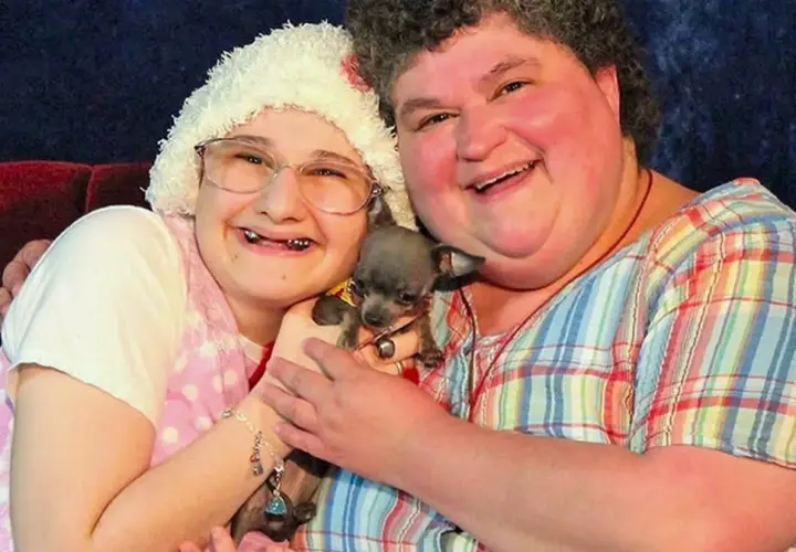 Gypsy Rose Blanchard i jej matka, Dee Dee, uśmiechają się do aparatu, trzymając małego psa.