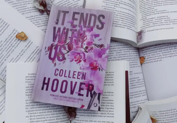 Książka "It Ends With Us" Colleen Hoover na tle innych otwartych książek.