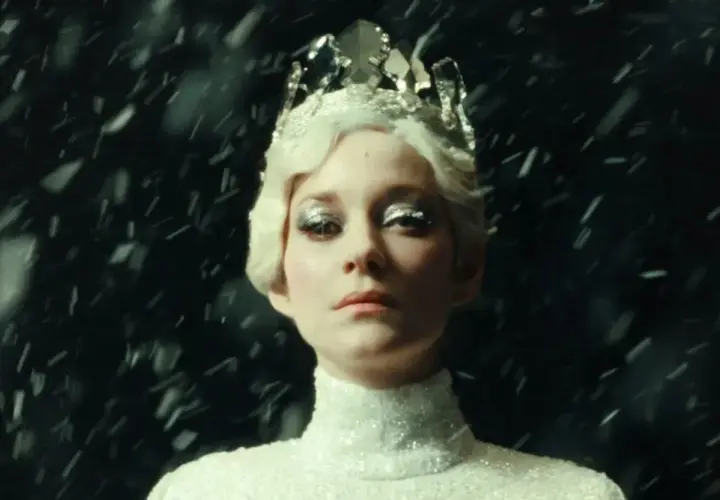 Marion Cotillard w koronie i błyszczącej sukni, otoczona śniegiem, jak z jej filmów.
