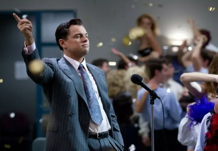 Jordan Belfort, znany jako wilk z Wall Street, przemawia do tłumu na imprezie, podczas gdy konfetti opada wokół.