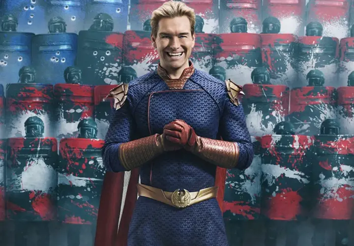 Homelander z "The Boys" sezon 5, uśmiechnięty na tle tarcz z wizerunkiem amerykańskiej flagi i śladami kul.