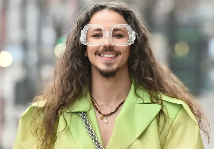 Uśmiechnięty Michał Szpak w limonkowym żakiecie i transparentnych okularach. Czy Michał Szpak jest gejem? To pytanie nurtuje wielu, ale jego styl i pewność siebie mówią same za siebie.