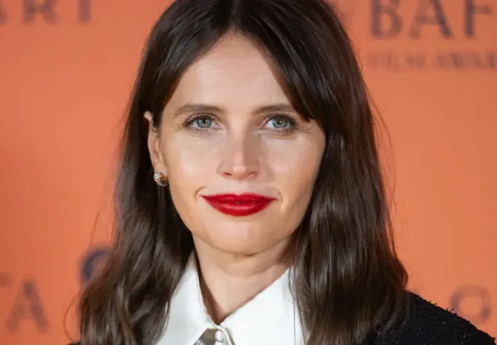 Felicity Jones, znana z wielu filmów, z uśmiechem i wyrazistą szminką na ustach.