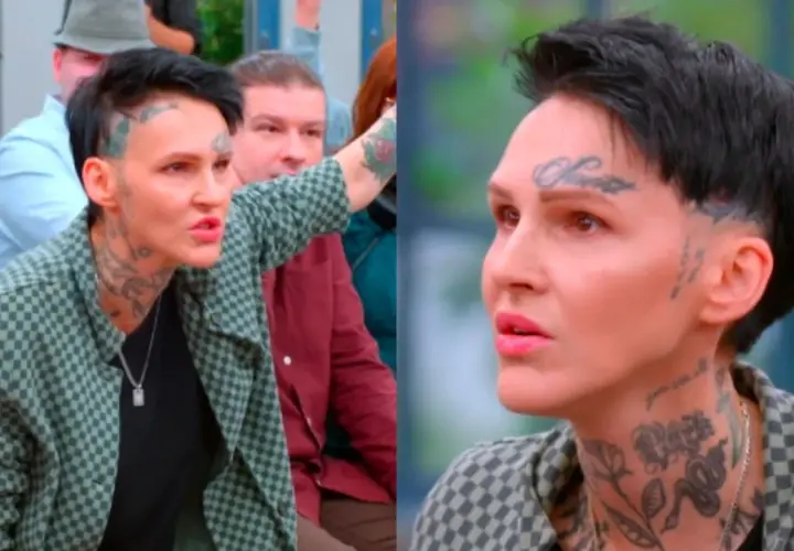 Agnieszka Chylińska z tatuażami na twarzy i szyi, w kratkowanej marynarce, mówi do ludzi. W tle widać inne osoby.