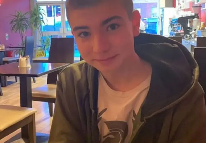 Młody mężczyzna, syn Sinead O'Connor, siedzi w kawiarni, ubrany w bluzę z kapturem.