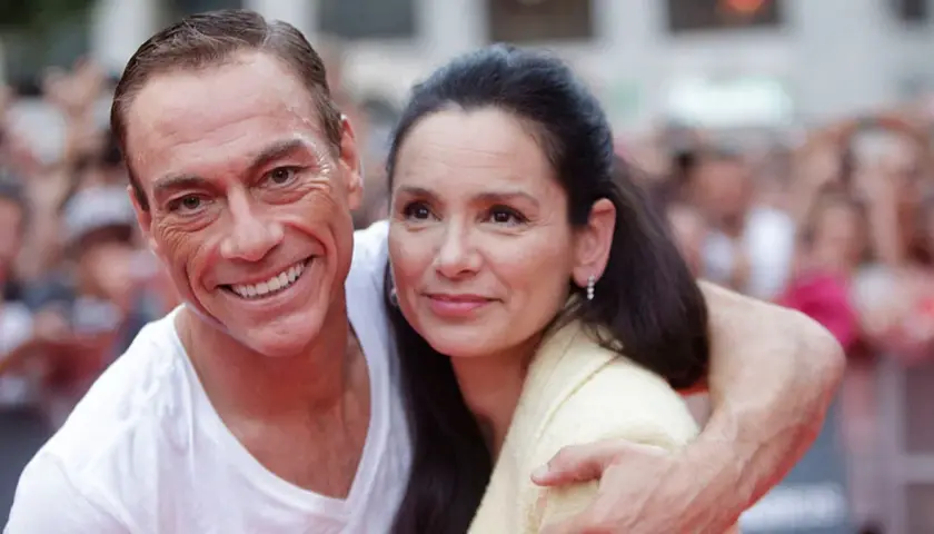 Jean-Claude Van Damme z uśmiechem obejmuje swoją żonę.