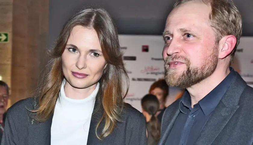 Piotr Adamczyk z żoną, piękną kobietą o długich włosach, na wydarzeniu.