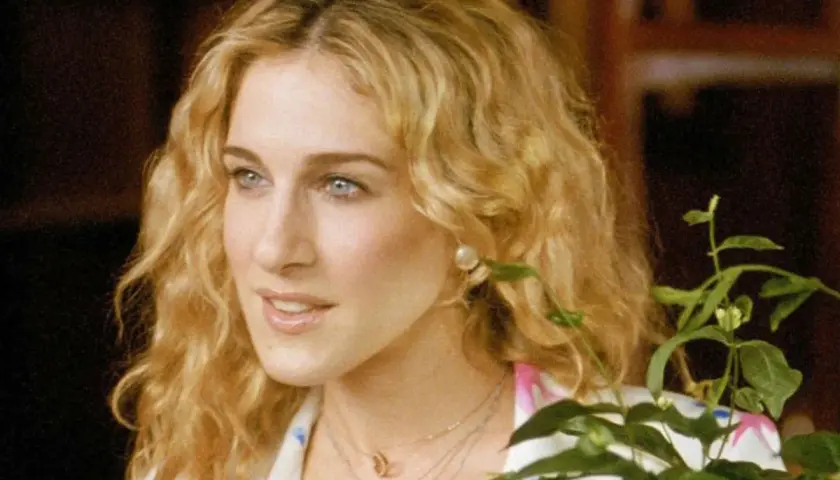 Sarah Jessica Parker w jednym ze swoich filmów, z burzą blond loków i delikatnym uśmiechem.