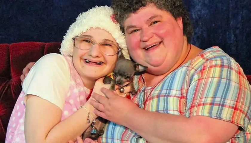 Gypsy Rose Blanchard i jej matka, Dee Dee, uśmiechają się do aparatu, trzymając małego psa.