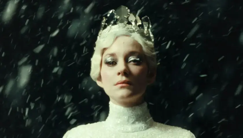 Marion Cotillard w koronie i błyszczącej sukni, otoczona śniegiem, jak z jej filmów.