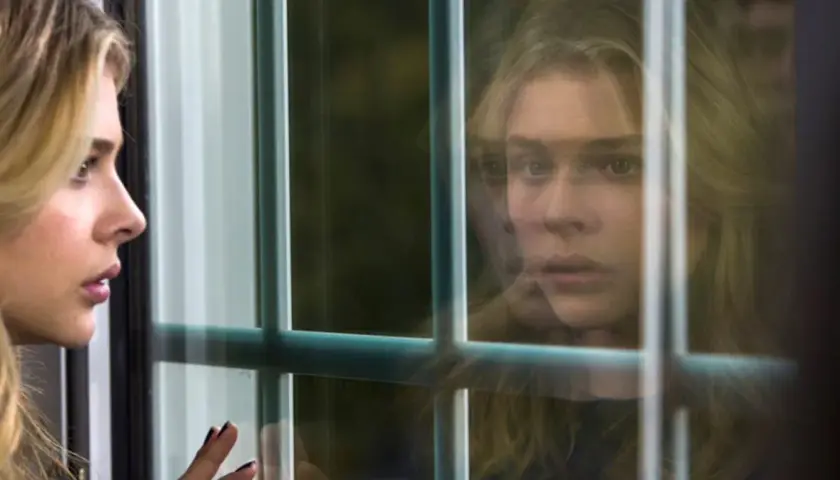 Chloë Grace Moretz w filmach, zamyślona, patrzy przez okno.