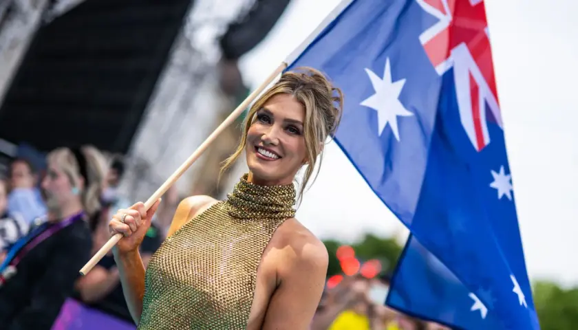 Uśmiechnięta kobieta z flagą Australii, dumna reprezentacja kraju na Eurowizji.