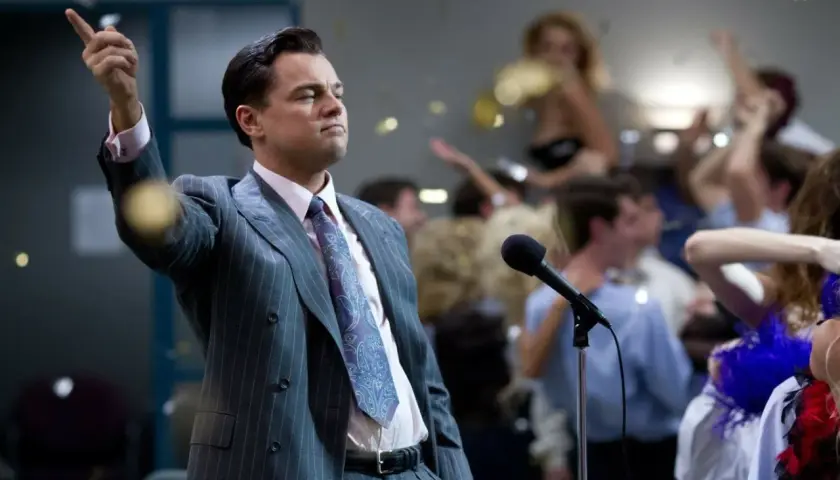 Jordan Belfort, znany jako wilk z Wall Street, przemawia do tłumu na imprezie, podczas gdy konfetti opada wokół.