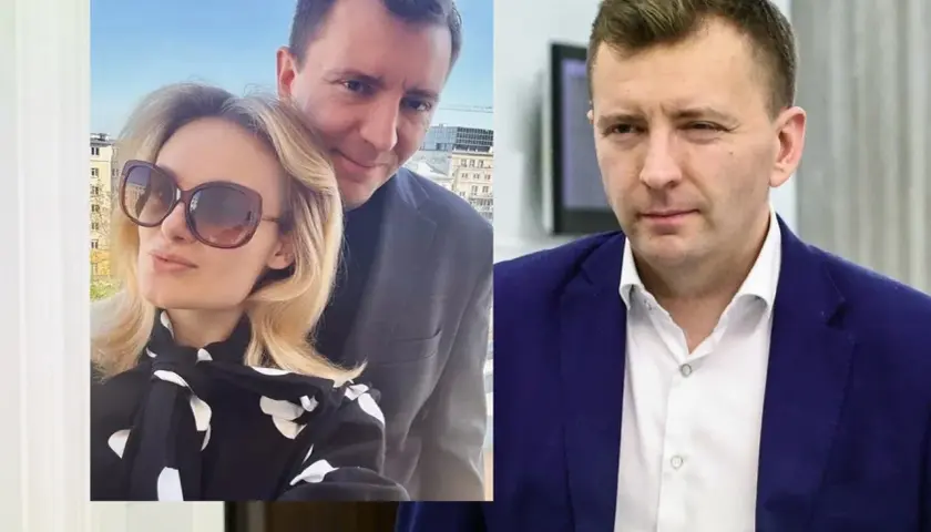 Łukasz Grabarczyk z żoną, uśmiechnięci na tle miasta. Obok polityk w granatowej marynarce.