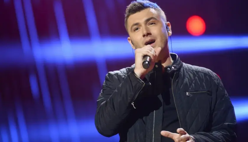 Kamil Bednarek śpiewa na scenie, myśląc o swojej żonie.