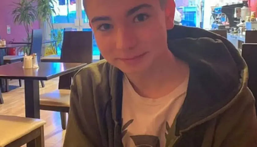 Młody mężczyzna, syn Sinead O'Connor, siedzi w kawiarni, ubrany w bluzę z kapturem.