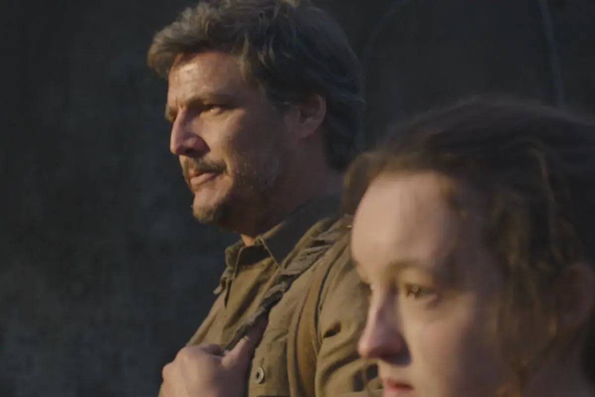 Joel i Ellie z serialu The Last of Us na tle ciemnej ściany.
