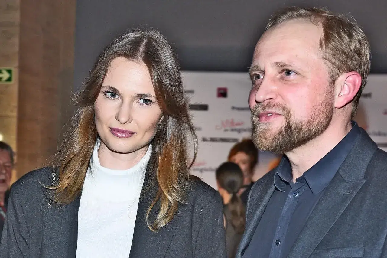 Piotr Adamczyk z żoną, piękną kobietą o długich włosach, na wydarzeniu.