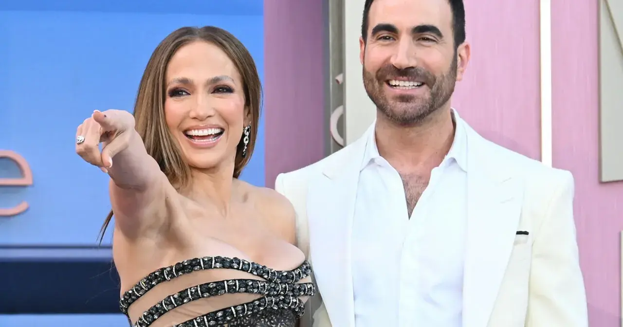 Jennifer Lopez i jej mąż Ben Affleck na czerwonym dywanie. Ona wskazuje palcem, on uśmiecha się.