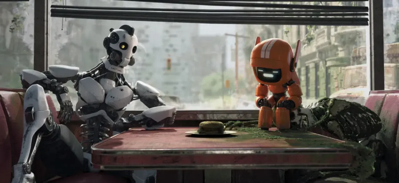 Dwa roboty siedzą przy stole w zniszczonym mieście. Jeden, duży i biały, wygląda na zamyślonego. Drugi, mały i pomarańczowy, patrzy na burgera. To scena z "Miłość, śmierć i roboty".