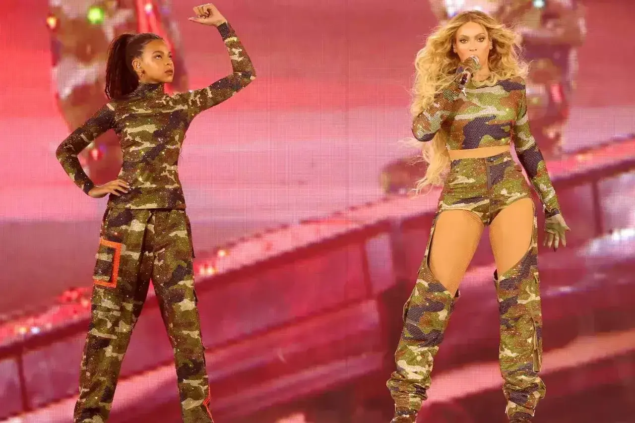 Blue Ivy Carter i Beyoncé w błyszczących strojach moro na scenie.
