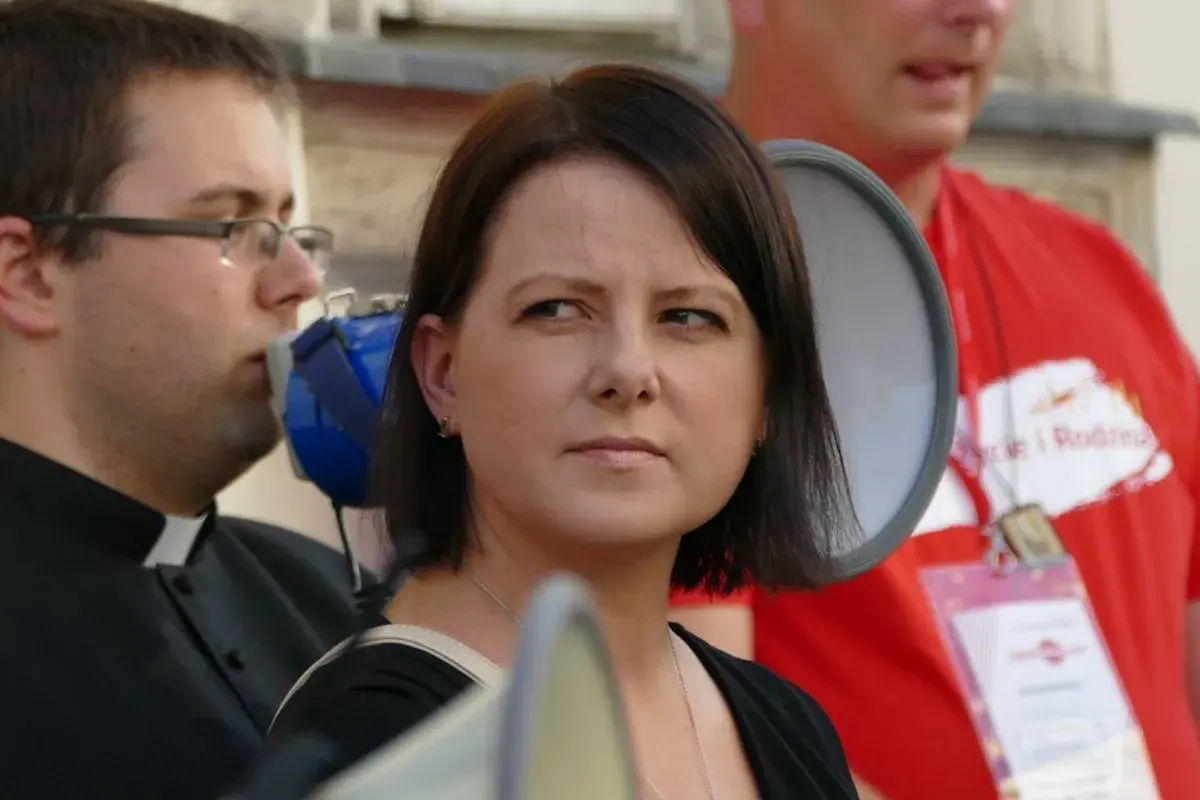 Kaja Godek z dziećmi na proteście. Kobieta z megafonem, obok ksiądz i mężczyzna w czerwonej koszulce.