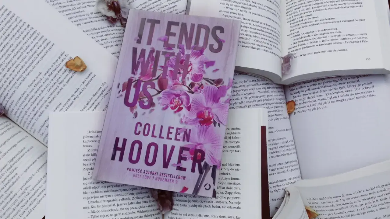 Książka "It Ends With Us" Colleen Hoover na tle innych otwartych książek.