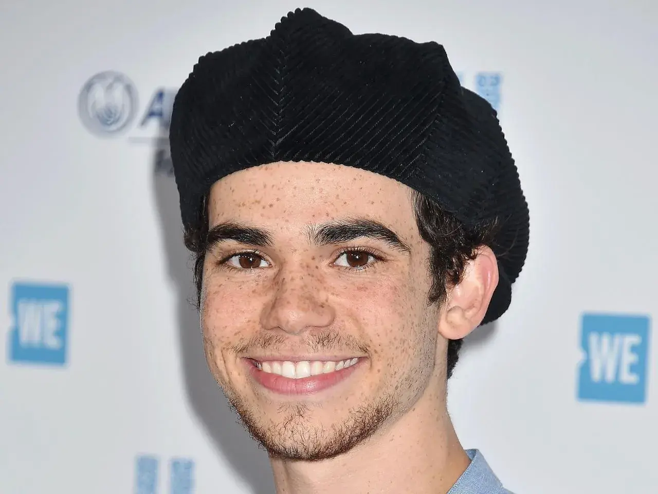 Uśmiechnięty Cameron Boyce w czarnej beretce, znany z filmów, seriali i programów.