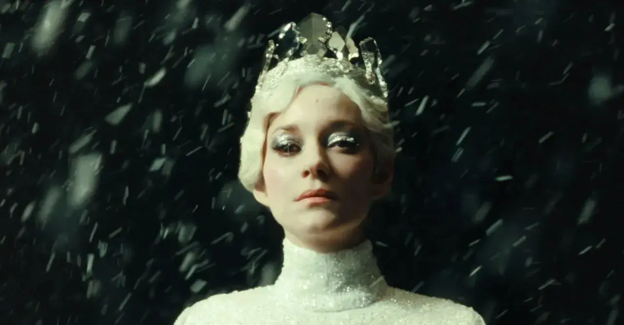 Marion Cotillard w koronie i błyszczącej sukni, otoczona śniegiem, jak z jej filmów.