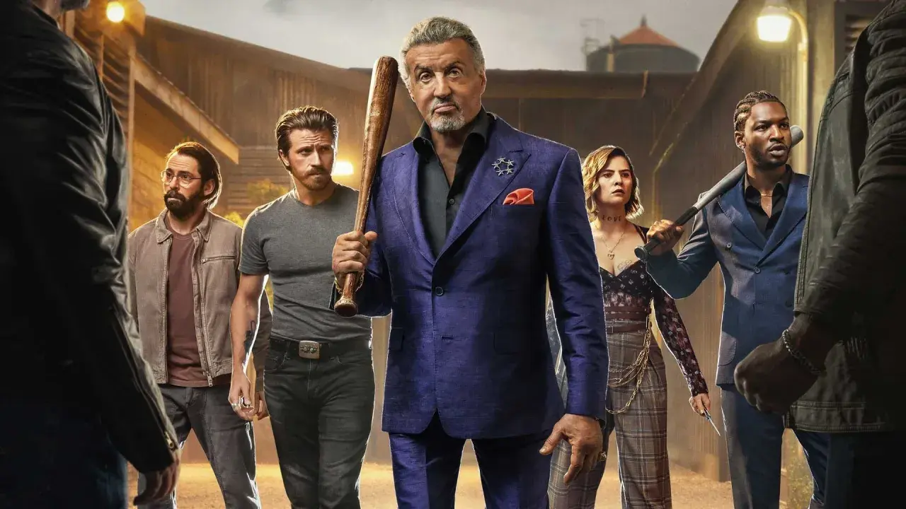 Sylvester Stallone jako Dwight Manfredi z kijem baseballowym, otoczony przez ekipę. Zapowiedź Tulsa King sezon 3.