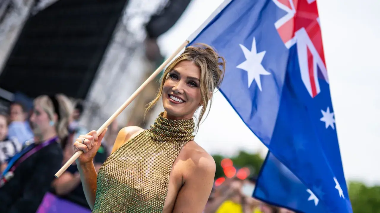 Uśmiechnięta kobieta z flagą Australii, dumna reprezentacja kraju na Eurowizji.