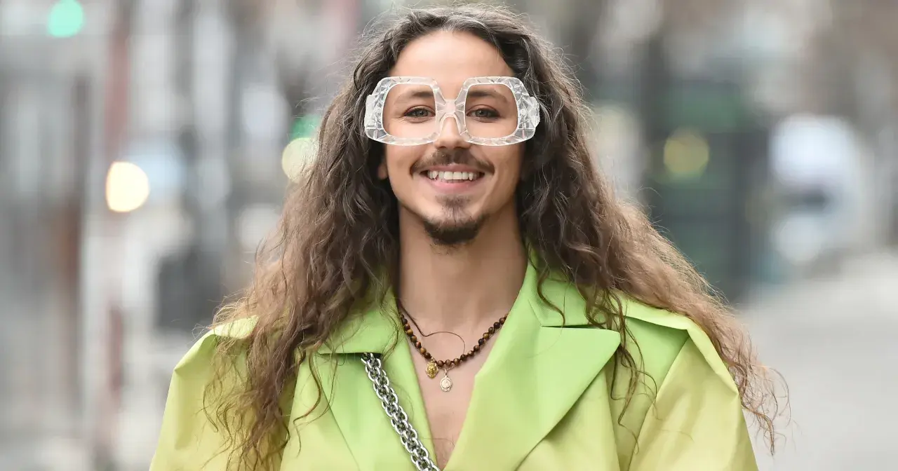Uśmiechnięty Michał Szpak w limonkowym żakiecie i transparentnych okularach. Czy Michał Szpak jest gejem? To pytanie nurtuje wielu, ale jego styl i pewność siebie mówią same za siebie.