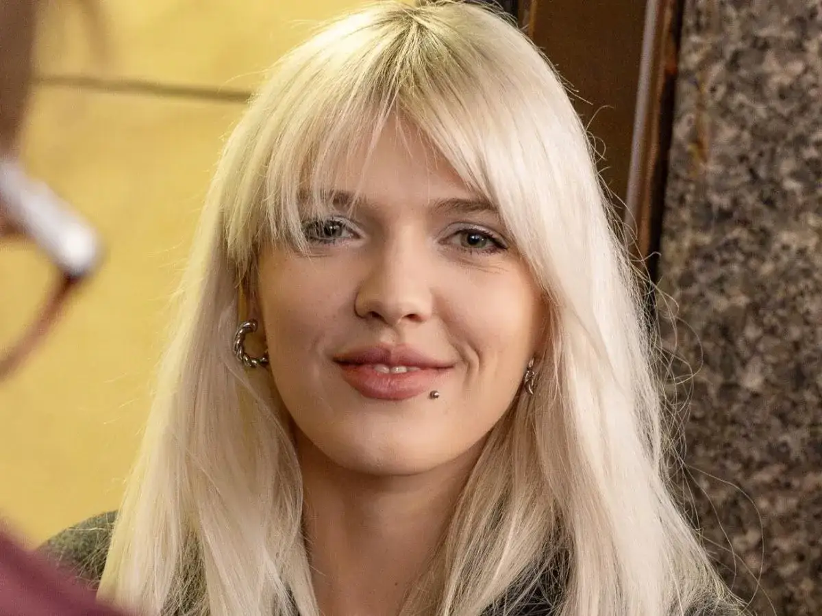 Uśmiechnięta Daria Zawiałow z blond włosami i kolczykiem w wardze. Czyżby rozmawiała z mężem?