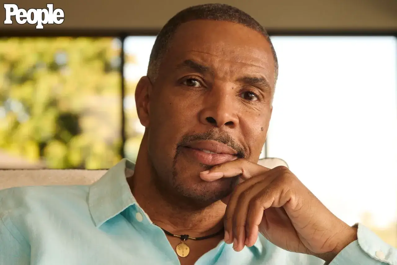 Eriq La Salle, zamyślony, opiera podbr&oacute;dek na dłoni. Ma na sobie błękitną koszulę i naszyjnik.