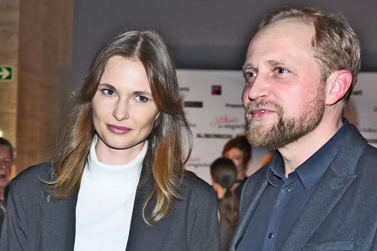 Piotr Adamczyk z żoną, piękną kobietą o długich włosach, na premierze.