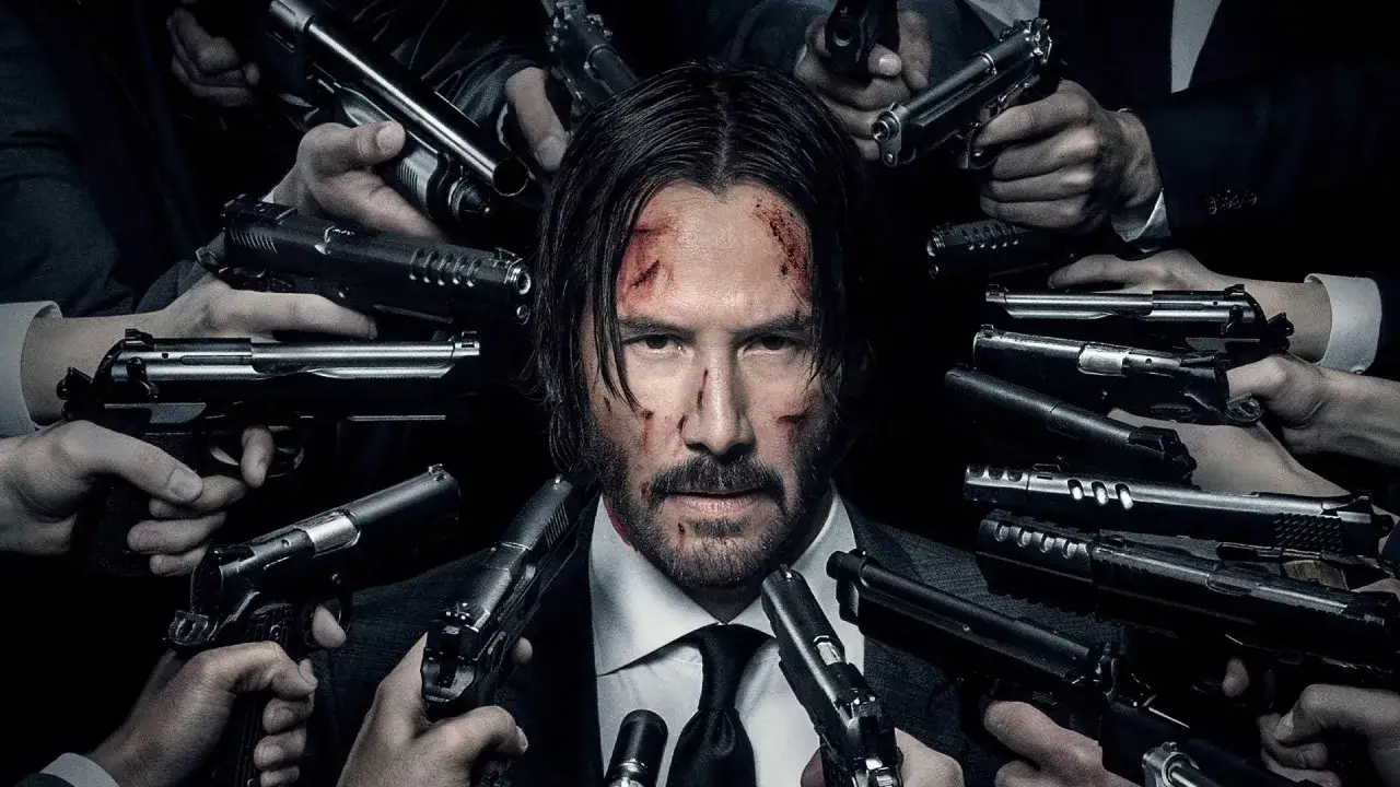 John Wick, z zakrwawioną twarzą, otoczony przez dziesiątki pistolet&oacute;w, gotowy na kolejną misję w stylu 